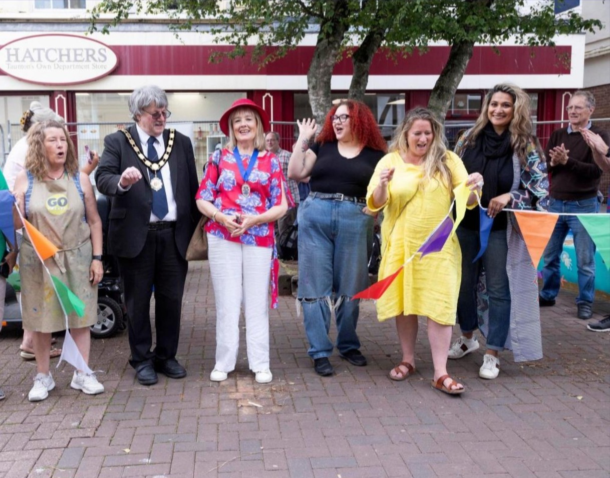 Anira Khokhar at a ribbon-cutting ceremony with bunting outside Hatchers department store, alongside the Mayor and other guests