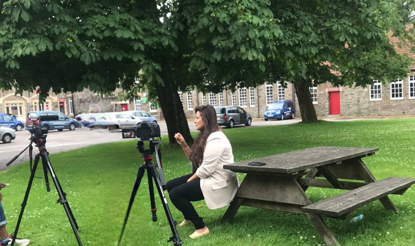 Anira Khokhar being filmed outdoors by two cameras for a BBC documentary on COVID