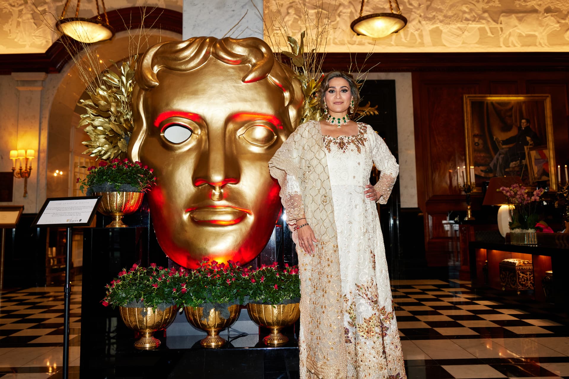 Anira Khokhar beside the golden BAFTA mask at the BAFTA Film Awards