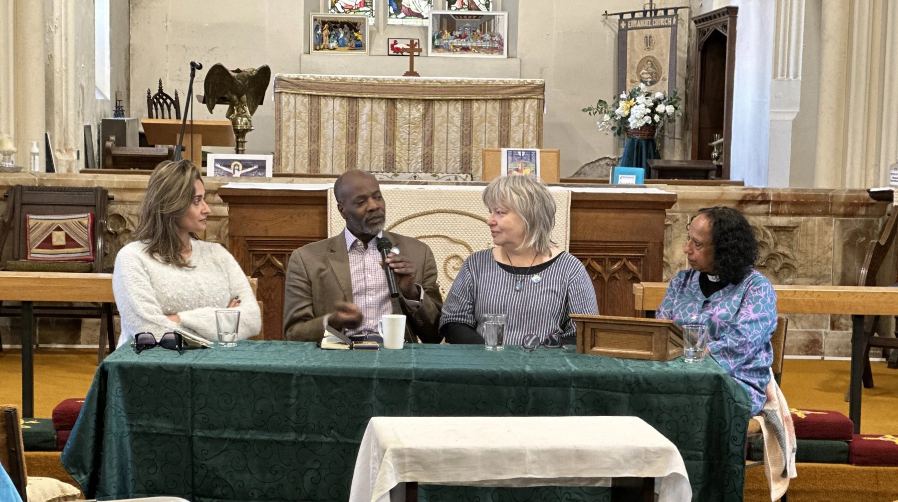 Anira Khokhar speaking on a panel discussion in a church
